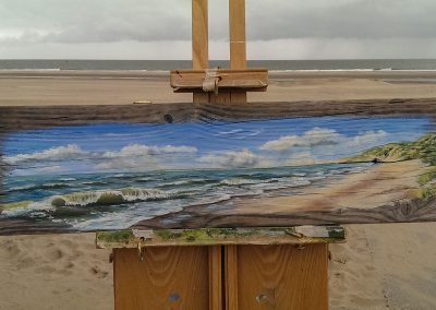 gedenkschilderij op drijfhout met strand en zee